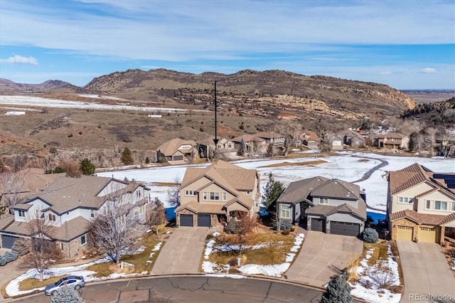 snowy aerial view featuring a residential view and a mountain view