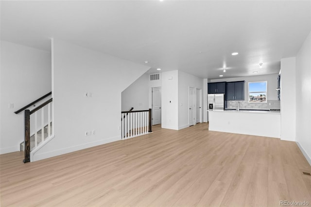 2740 W 68th Ave, Denver, CO 80221 - unfurnished living room with light wood-type flooring and recessed lighting