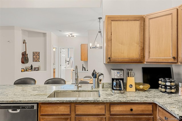 kitchen with brown cabinets, light stone counters, a sink, and dishwasher