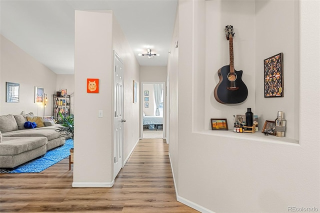 hall with baseboards and wood finished floors