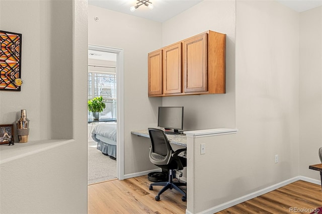 office space featuring light wood-type flooring and baseboards