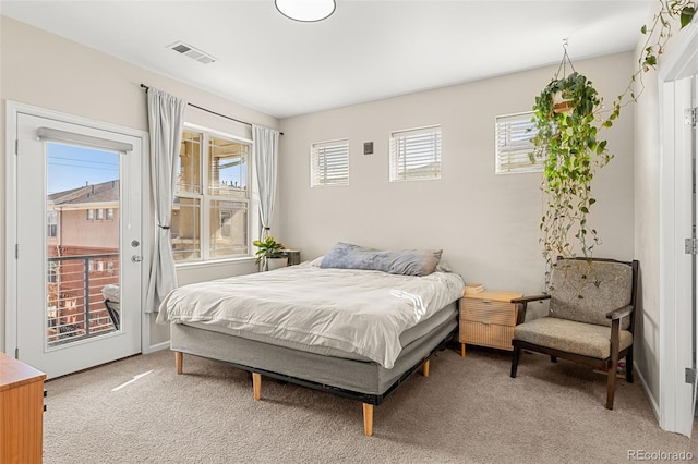bedroom featuring visible vents, light carpet, multiple windows, and access to exterior