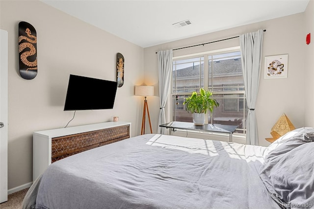 carpeted bedroom featuring baseboards and visible vents