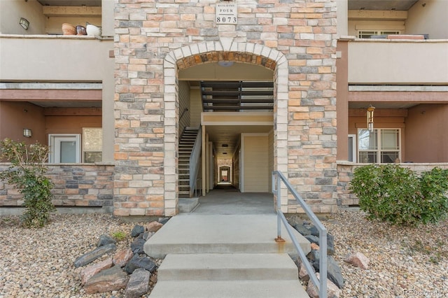 doorway to property featuring stucco siding and stone siding