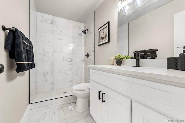 bathroom with tiled shower, vanity, and toilet