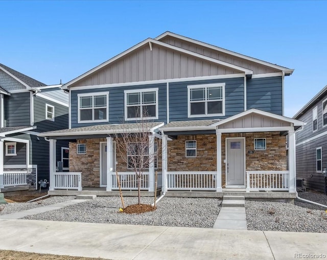 22292 E 7th Pl, Aurora, CO 80018 - view of front of property featuring board and batten siding, covered porch, and stone siding