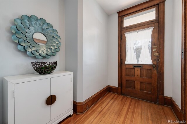 foyer with light wood-style flooring and baseboards