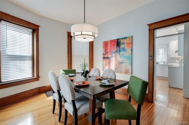 dining area featuring light wood-type flooring and baseboards