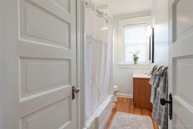 bathroom with wood finished floors, vanity, toilet, and baseboards