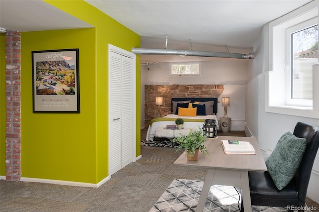 bedroom with carpet floors, multiple windows, a fireplace, and a closet