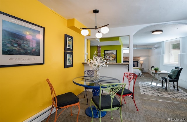 dining room featuring carpet floors, a chandelier, and a baseboard radiator