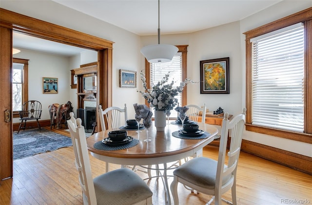dining room with plenty of natural light, light wood-style floors, and baseboards