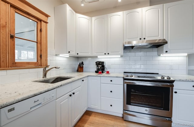 kitchen featuring stainless steel electric range, under cabinet range hood, a sink, dishwasher, and backsplash