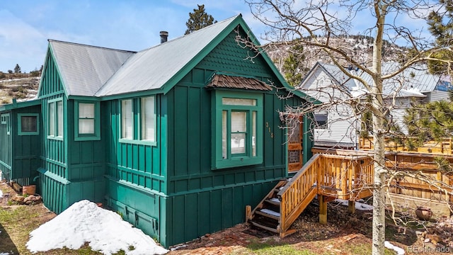 view of side of home featuring board and batten siding and metal roof