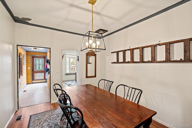 dining space featuring a chandelier, wood finished floors, and baseboards
