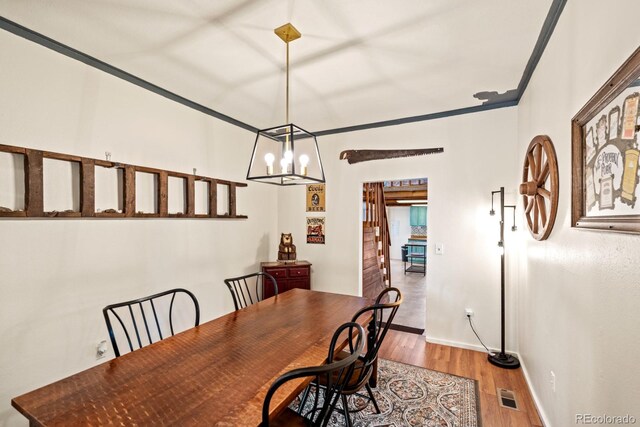 dining room with a chandelier, wood finished floors, and baseboards