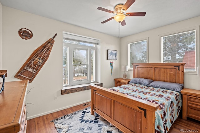 bedroom featuring light wood finished floors, baseboards, and a ceiling fan