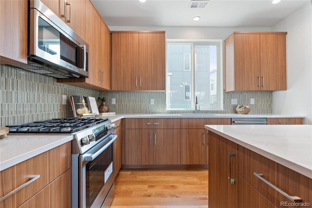 8711 E Hampden Ave Unit 21, Denver, CO 80231 - kitchen with appliances with stainless steel finishes, light countertops, decorative backsplash, and recessed lighting