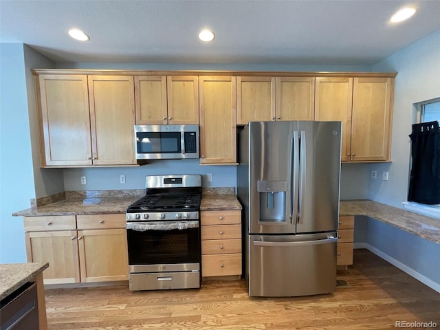 kitchen featuring light brown cabinets, light hardwood / wood-style floors, and appliances with stainless steel finishes