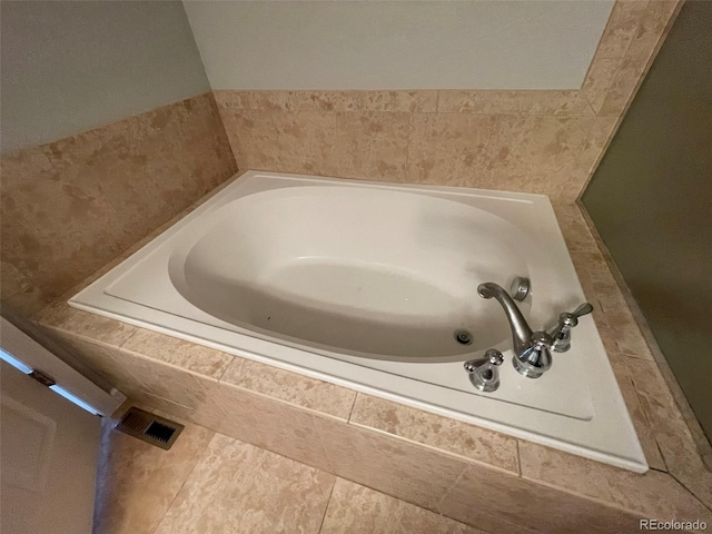 bathroom with tile patterned flooring and a relaxing tiled tub