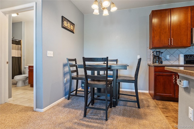 2682 S Cathay Way Unit 307, Aurora, CO 80013 - dining room featuring a chandelier, light carpet, and baseboards