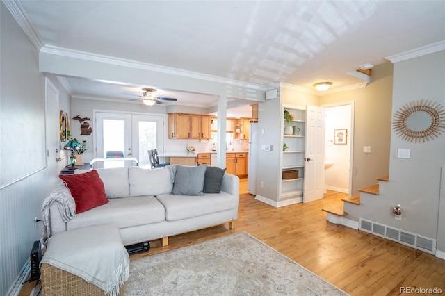 living room featuring ceiling fan, light hardwood / wood-style flooring, and ornamental molding