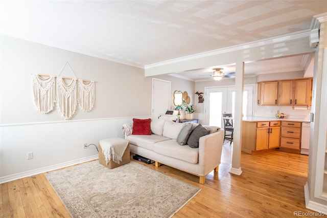 living room with wood walls, light hardwood / wood-style floors, crown molding, and french doors