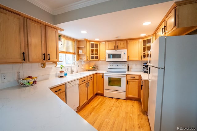 kitchen with light wood-type flooring, tasteful backsplash, white appliances, crown molding, and sink