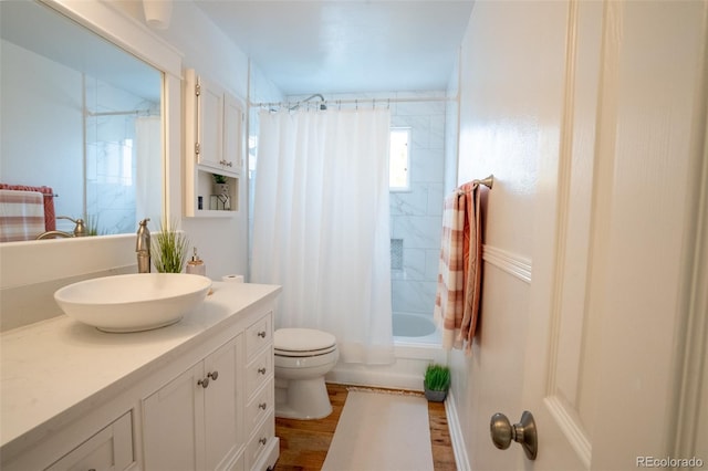 full bathroom with shower / bath combination with curtain, vanity, wood-type flooring, and toilet