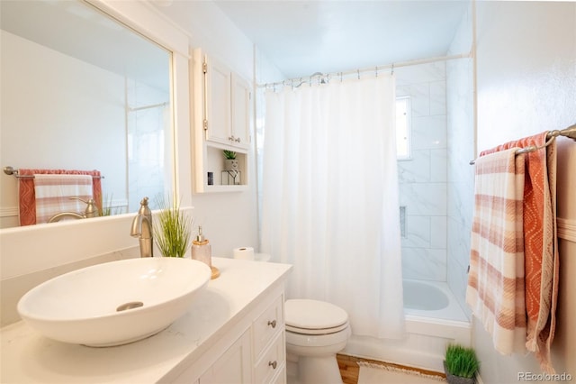 full bathroom with hardwood / wood-style floors, vanity, shower / tub combo, and toilet