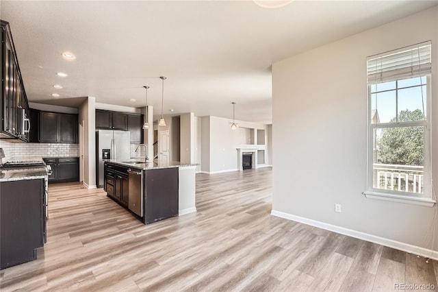 6612 S Muscadine Ct, Aurora, CO 80016 - kitchen with appliances with stainless steel finishes, tasteful backsplash, light wood finished floors, open floor plan, and baseboards