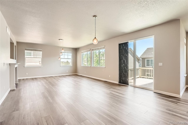 6612 S Muscadine Ct, Aurora, CO 80016 - unfurnished living room with wood finished floors, a textured ceiling, and baseboards