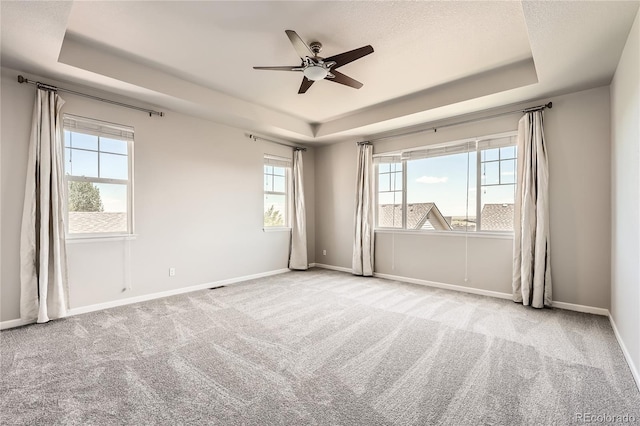 6612 S Muscadine Ct, Aurora, CO 80016 - carpeted empty room with a raised ceiling, healthy amount of natural light, ceiling fan, and baseboards
