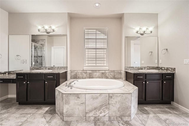 6612 S Muscadine Ct, Aurora, CO 80016 - full bathroom with a garden tub, a shower stall, two vanities, baseboards, and recessed lighting