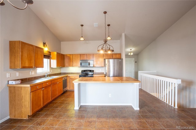 kitchen with pendant lighting, sink, appliances with stainless steel finishes, high vaulted ceiling, and a kitchen island