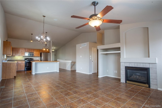 unfurnished living room featuring a tiled fireplace, lofted ceiling, sink, and ceiling fan with notable chandelier