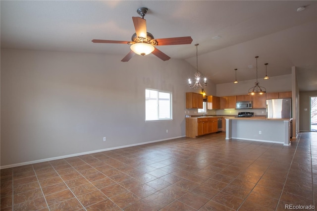 kitchen featuring a kitchen island, appliances with stainless steel finishes, ceiling fan with notable chandelier, decorative light fixtures, and sink