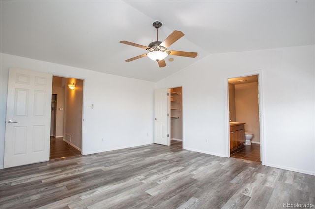 empty room with dark wood-type flooring, ceiling fan, and vaulted ceiling