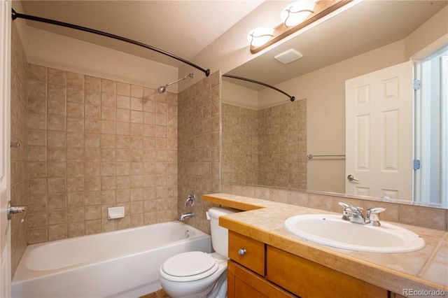 full bathroom with tiled shower / bath, vanity, and toilet