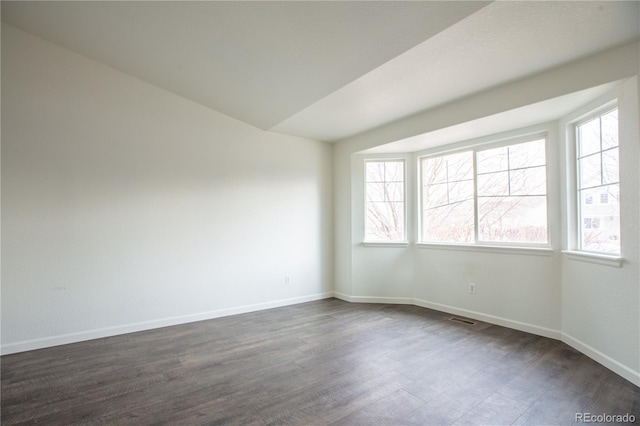 unfurnished room featuring dark hardwood / wood-style flooring and plenty of natural light