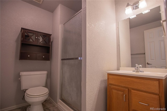 bathroom featuring vanity, an enclosed shower, and toilet