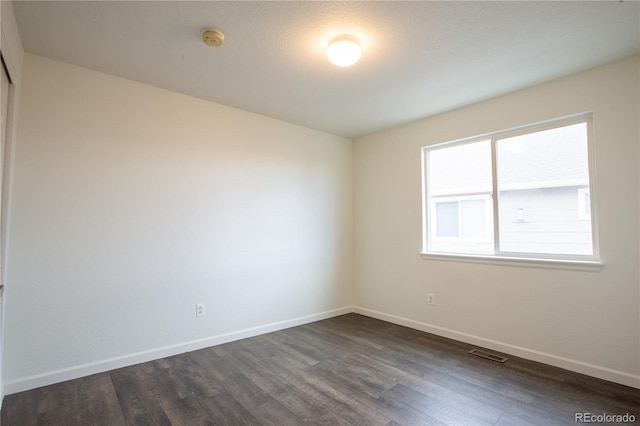 unfurnished room featuring dark wood-type flooring