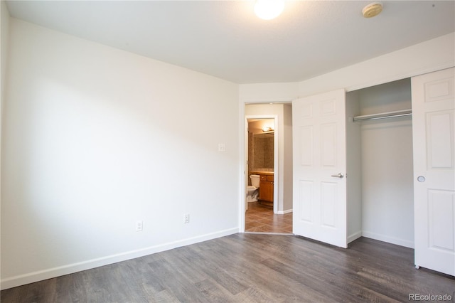 unfurnished bedroom featuring dark hardwood / wood-style floors and a closet