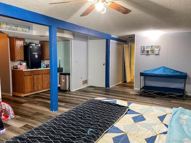 3190 S Joplin Ct, Aurora, CO 80013 - bedroom with freestanding refrigerator, wood finished floors, a textured ceiling, and a ceiling fan