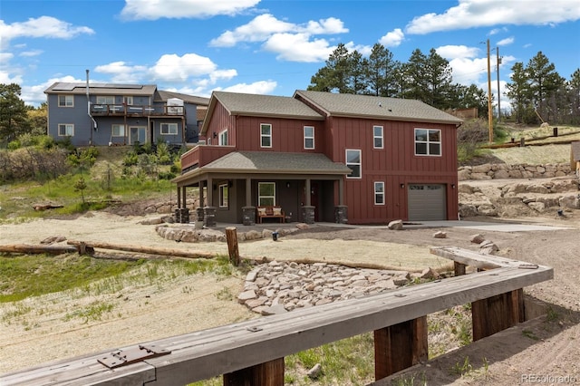 826 Meadow Ln, Palmer Lake, CO 80133 - view of front of home with board and batten siding, driveway, a shingled roof, and an attached garage