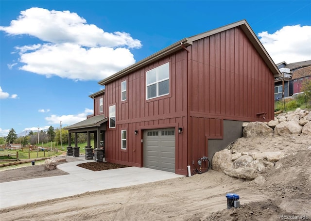 826 Meadow Ln, Palmer Lake, CO 80133 - view of property exterior with board and batten siding, an attached garage, and driveway