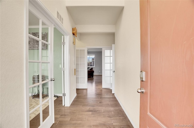 hallway featuring french doors and light hardwood / wood-style floors