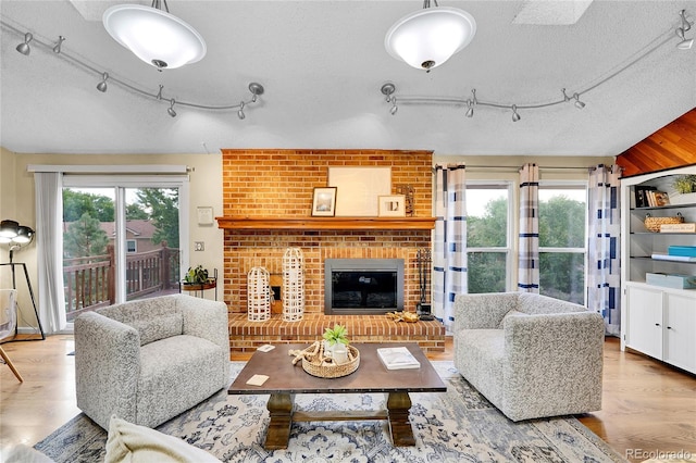 11149 Seton Pl, Westminster, CO 80031 - living area featuring track lighting, wood finished floors, a fireplace, and a textured ceiling