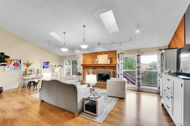 11149 Seton Pl, Westminster, CO 80031 - living area with a skylight, a textured ceiling, light wood-style flooring, a fireplace, and rail lighting