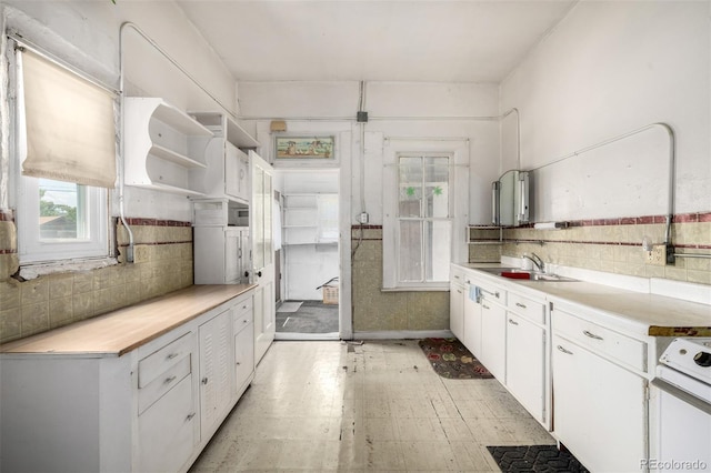 3907 Inca St Unit 3905, Denver, CO 80211 - kitchen featuring open shelves, light floors, white cabinetry, light countertops, and backsplash